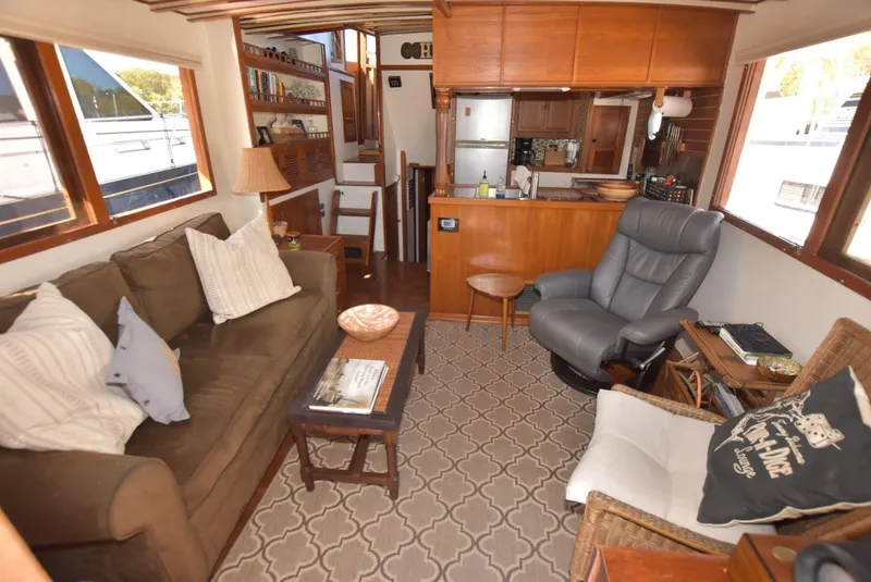 Slide: The Image of 1983 Krogen Trawler interior with cozy seating, wooden accents, and nautical decor. - 16