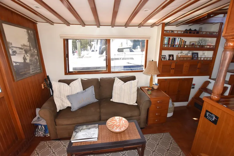 Slide: The Image of 1983 Krogen Trawler interior with cozy sofa, wooden decor, and nautical-themed accents. - 17