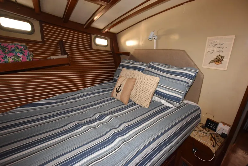 Slide: The Image of Cozy bedroom in 1983 Krogen Trawler with striped bedding and nautical decor. - 21