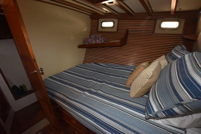 Slide: The Image of Cozy cabin interior of 1983 Krogen Trawler with striped bedding and wooden accents. - 22