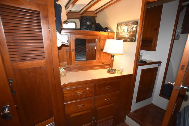 Slide: The Image of 1983 Krogen Trawler interior with wooden cabinetry, mirror, and lamp. Cozy nautical design. - 24