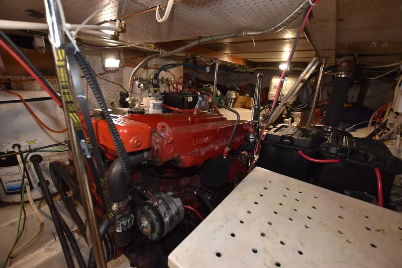 Slide: The Image of Engine room of a 1983 Krogen Trawler, featuring a red engine and various mechanical components. - 32
