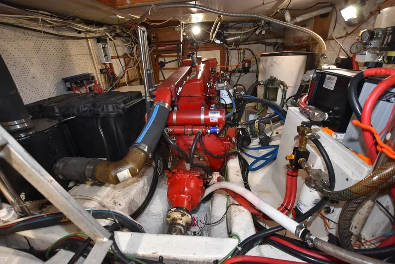 Slide: The Image of Engine room of a 1983 Krogen Trawler with red engine and various mechanical components. - 33