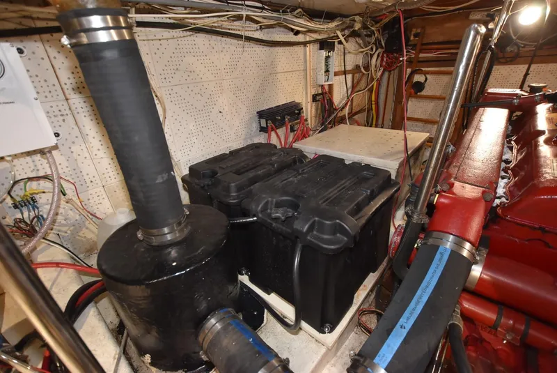 Slide: The Image of Engine room of a 1983 Krogen Trawler with visible machinery and wiring. - 35
