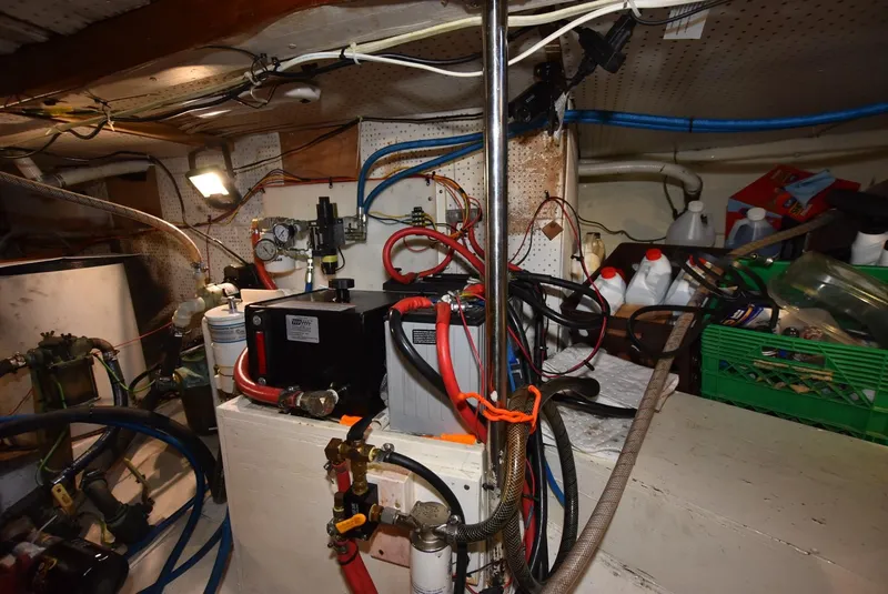 Slide: The Image of Engine room of a 1983 Krogen Trawler with various cables and equipment. - 36