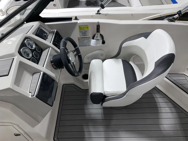 Slide: The Image of 2024 Starcraft SVX 210 boat cockpit with steering wheel and captain's chair. - 5
