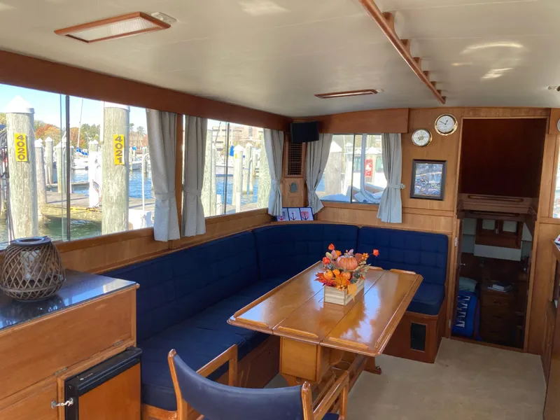 Slide: The Image of Interior of 1983 Grand Banks 42 Classic yacht with wooden dining area and blue seating. - 12