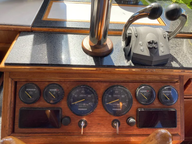Slide: The Image of Control panel of a 1983 Grand Banks 42 Classic yacht with gauges and throttle. - 15