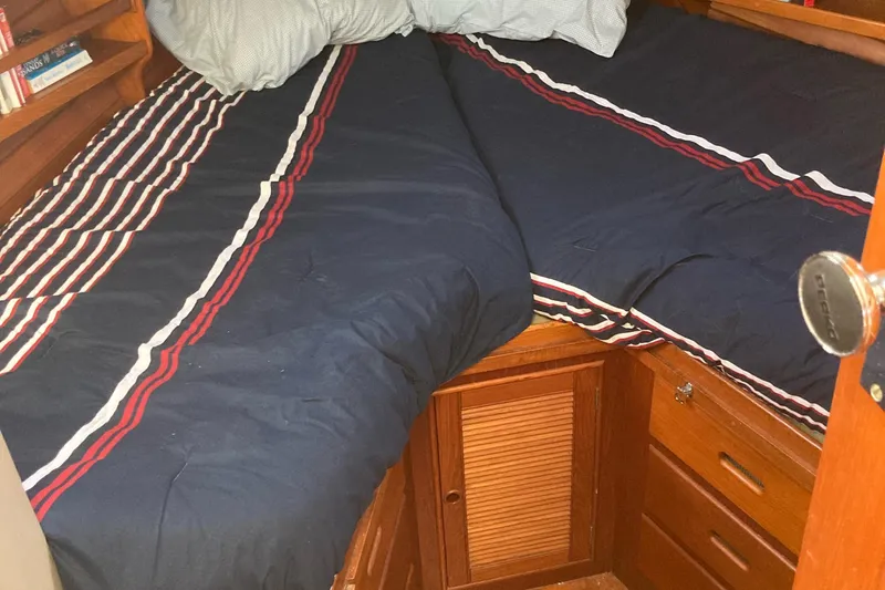 Slide: The Image of Cozy cabin bedroom in 1983 Grand Banks 42 Classic yacht with striped bedding. - 22