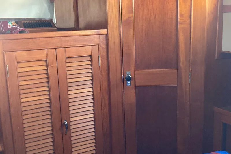 Slide: The Image of 1983 Grand Banks 42 Classic interior with wooden cabinets and doors. - 24