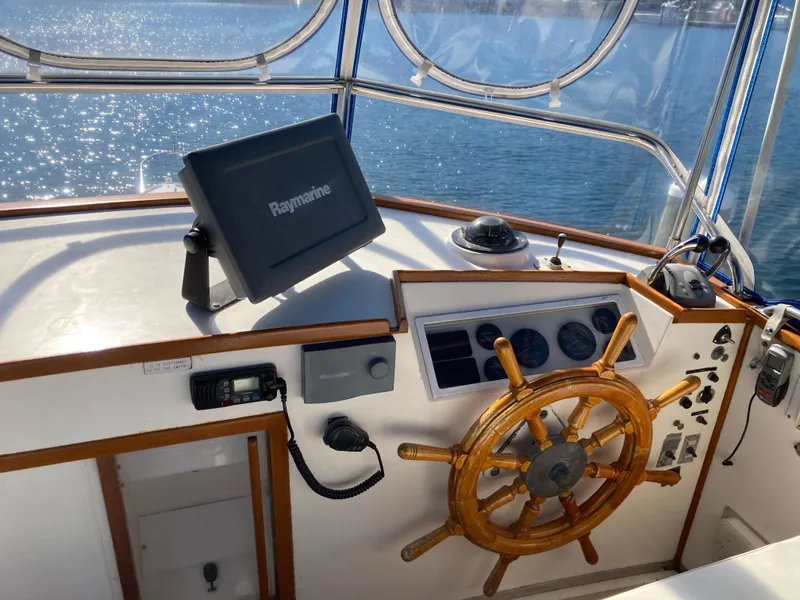 Slide: The Image of Helm of 1983 Grand Banks 42 Classic yacht with wooden wheel and navigation equipment. - 9