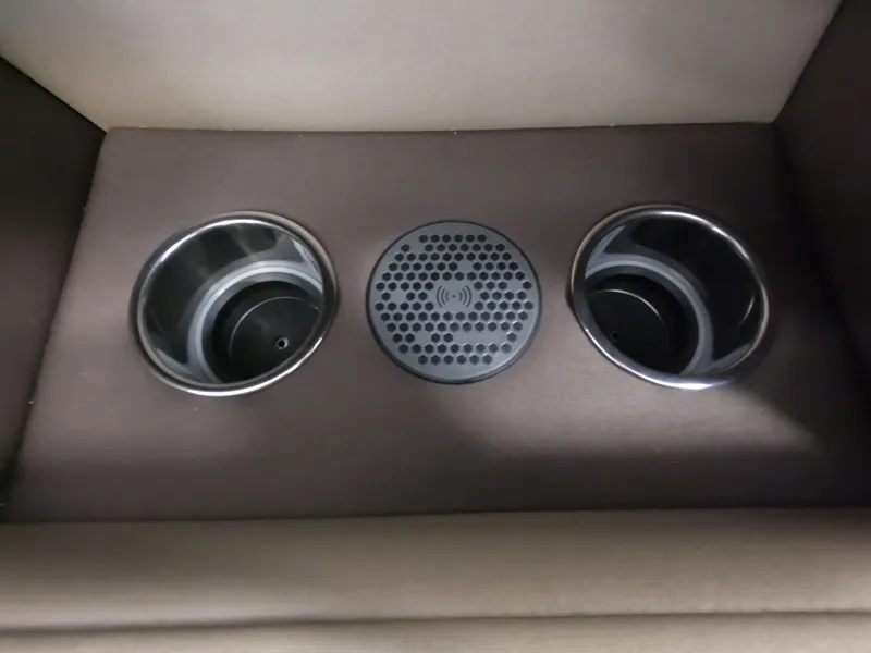 Slide: The Image of Vanderbilt 700T 2023 car interior with dual cup holders and wireless charging pad. - 16