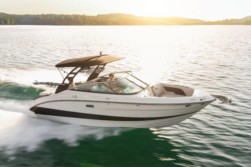 Slide: The Image of 2023 Sea Ray SLX 260 Surf boat cruising on a lake at sunset. - 0