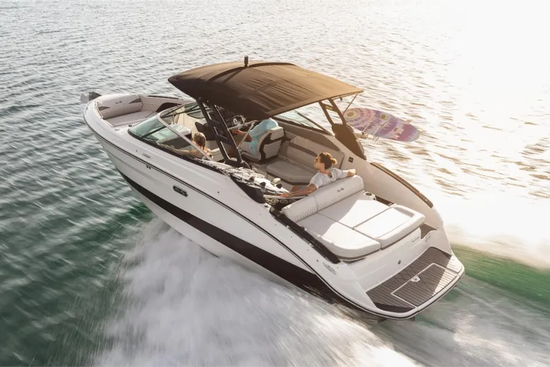 Slide: The Image of 2023 Sea Ray SLX 260 Surf boat cruising on water with passengers. - 1