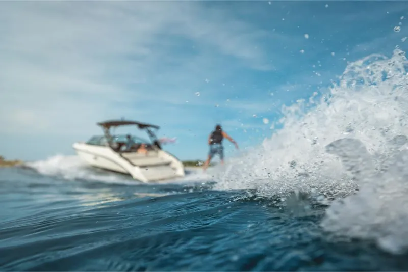 Slide: The Image of 2023 Sea Ray SLX 260 Surf boat with wakeboarder in action. - 10