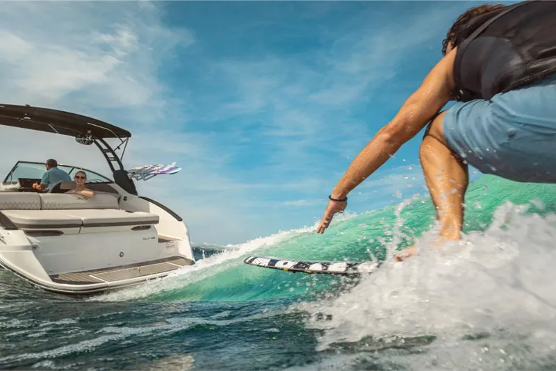 Slide: The Image of 2023 Sea Ray SLX 260 Surf boat with a person wakesurfing. - 13
