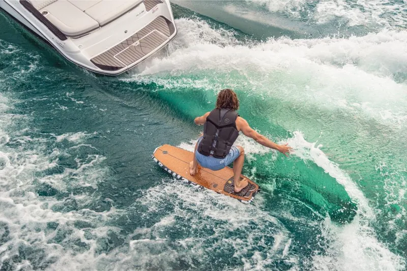 Slide: The Image of Person wakesurfing behind a 2023 Sea Ray SLX 260 Surf boat. - 14
