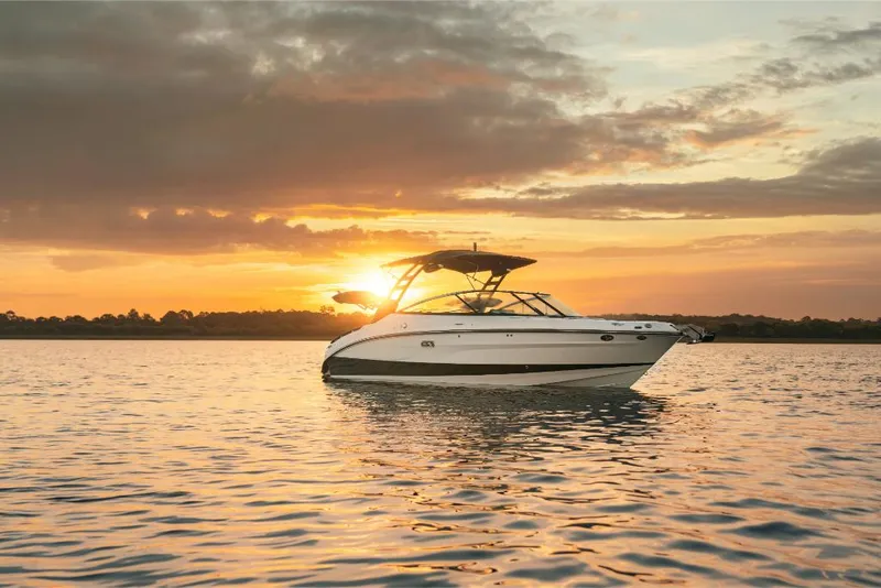 Slide: The Image of 2023 Sea Ray SLX 260 Surf boat on water at sunset. - 24