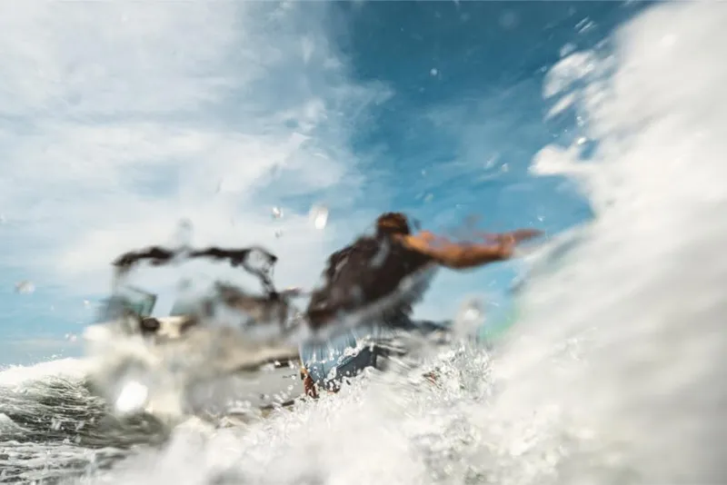 Slide: The Image of 2023 Sea Ray SLX 260 Surf in action, creating waves under a clear blue sky. - 8