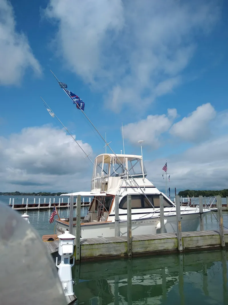 Slide: The Image of 1989 Egg Harbor 33 Sedan boat docked under a blue sky with clouds. - 12