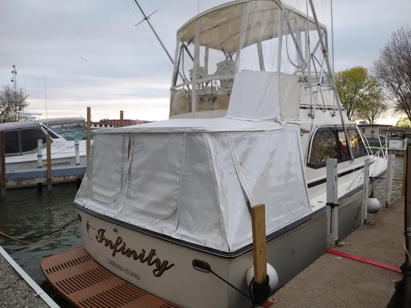 Slide: The Image of 1989 Egg Harbor 33 Sedan docked, featuring white canopy and wooden deck. - 16