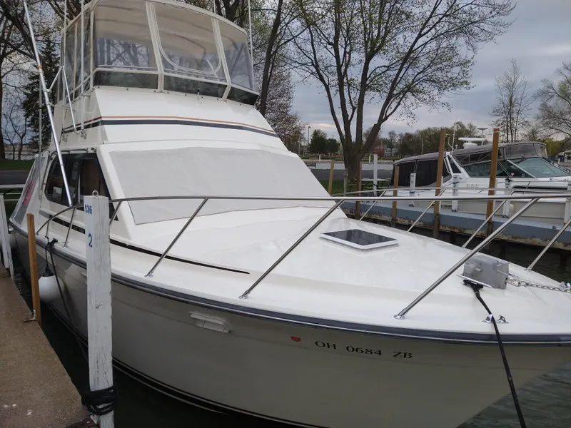 Slide: The Image of 1989 Egg Harbor 33 Sedan boat docked at marina, featuring a sleek white exterior. - 17