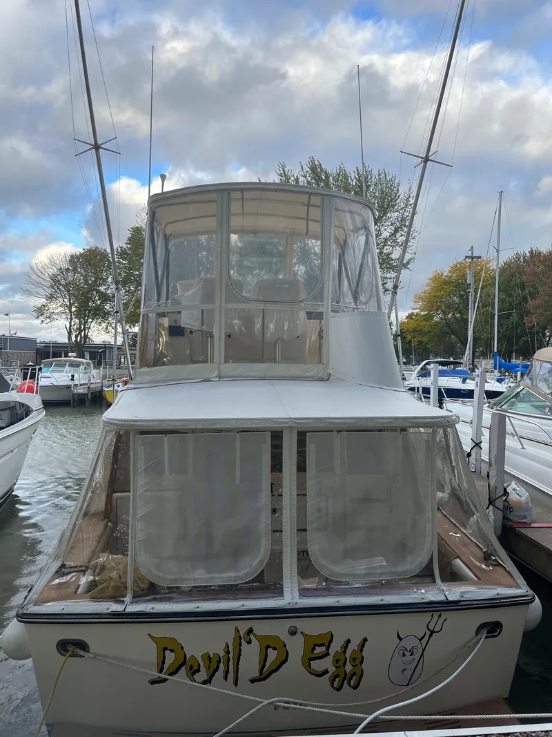 Slide: The Image of 1989 Egg Harbor 33 Sedan boat docked, named "Devil's Egg," with overcast sky. - 2