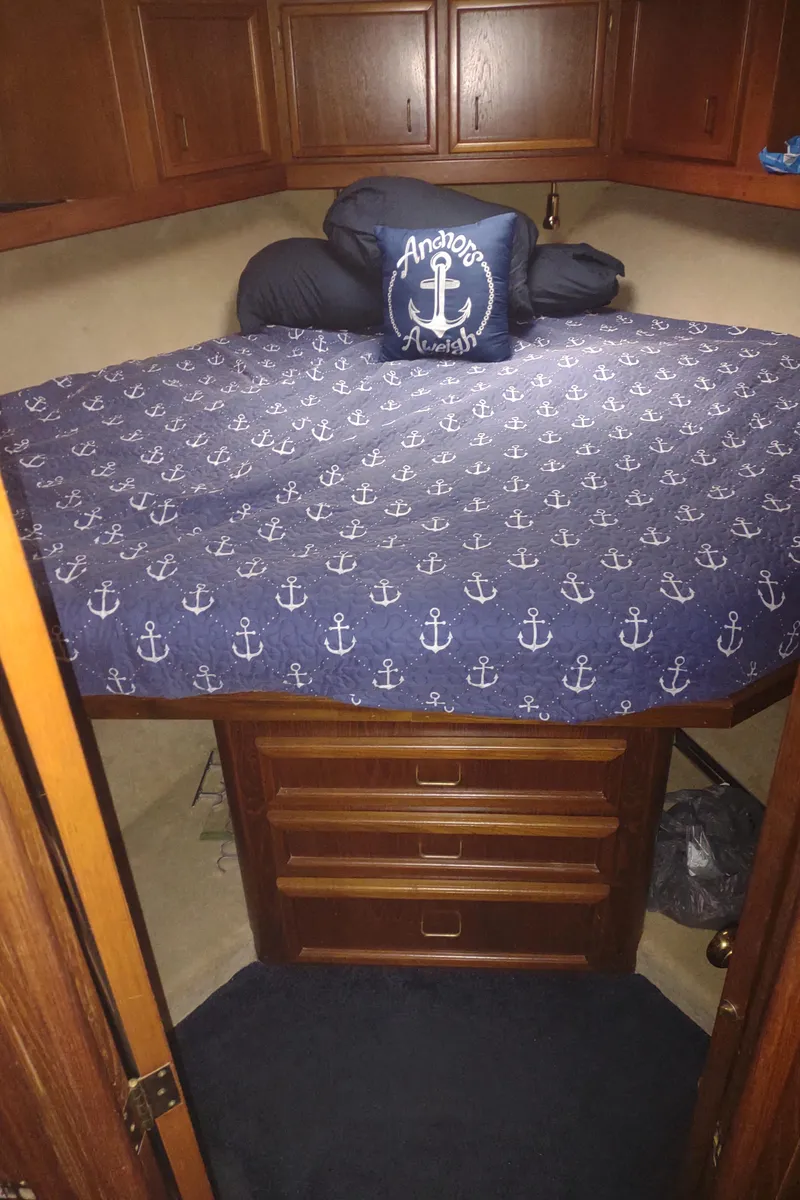 Slide: The Image of 1989 Egg Harbor 33 Sedan cabin with anchor-themed bedding and wooden storage cabinets. - 27