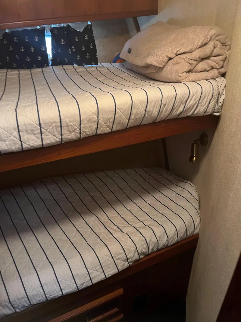 Slide: The Image of 1989 Egg Harbor 33 Sedan interior with striped bunk beds and nautical-themed curtains. - 29