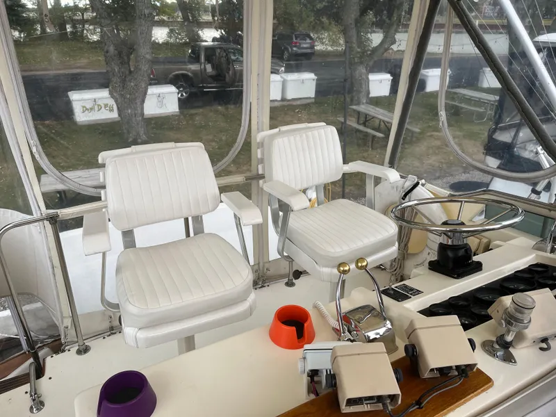 Slide: The Image of 1989 Egg Harbor 33 Sedan cockpit with white captain chairs and steering wheel. - 3