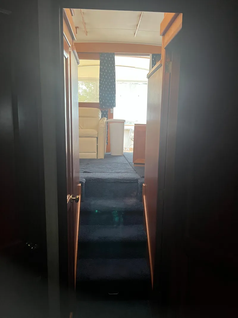 Slide: The Image of Interior view of 1989 Egg Harbor 33 Sedan yacht with carpeted stairs and wooden paneling. - 33