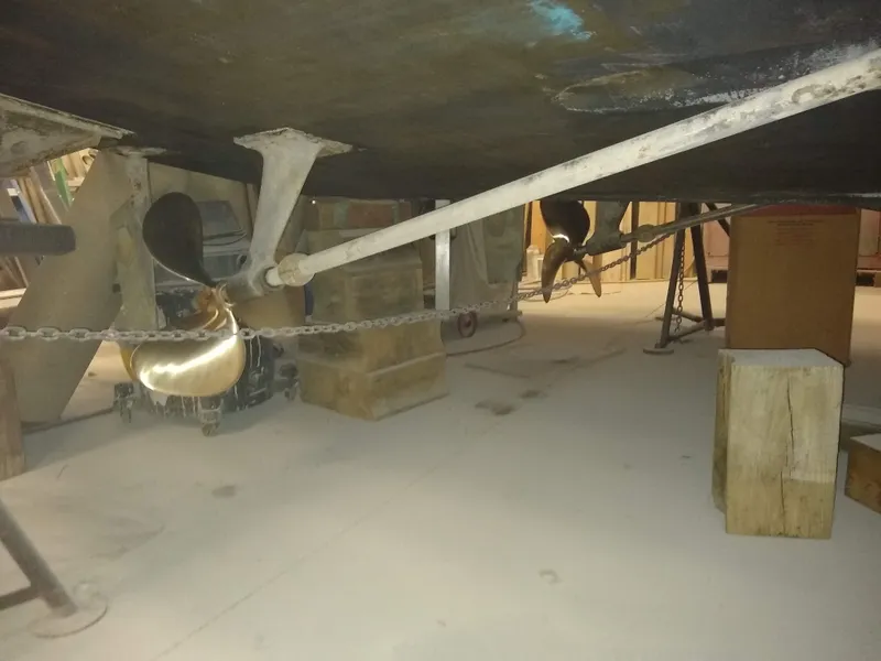 Slide: The Image of Underneath view of a 1989 Egg Harbor 33 Sedan boat, showing propellers and supports. - 38