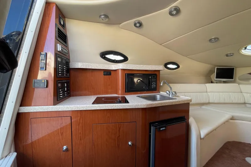 Slide: The Image of 2006 Regal 2665 Commodore yacht interior with kitchenette and seating area. - 1