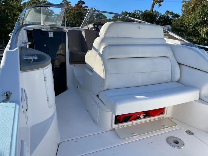 Slide: The Image of 2006 Regal 2665 Commodore boat interior with white seating and storage compartment. - 10