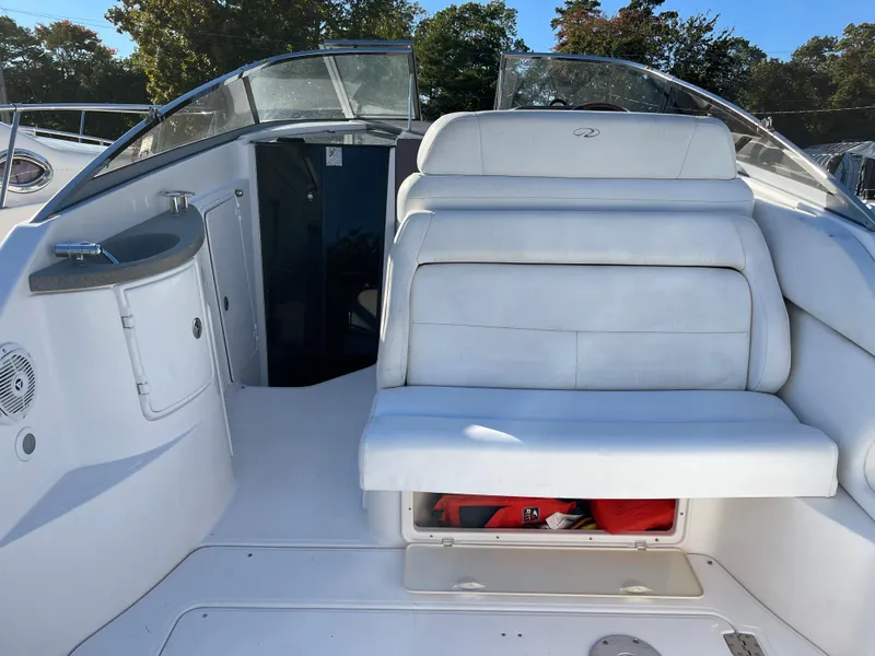 Slide: The Image of 2006 Regal 2665 Commodore boat interior with white seating and storage compartment. - 11