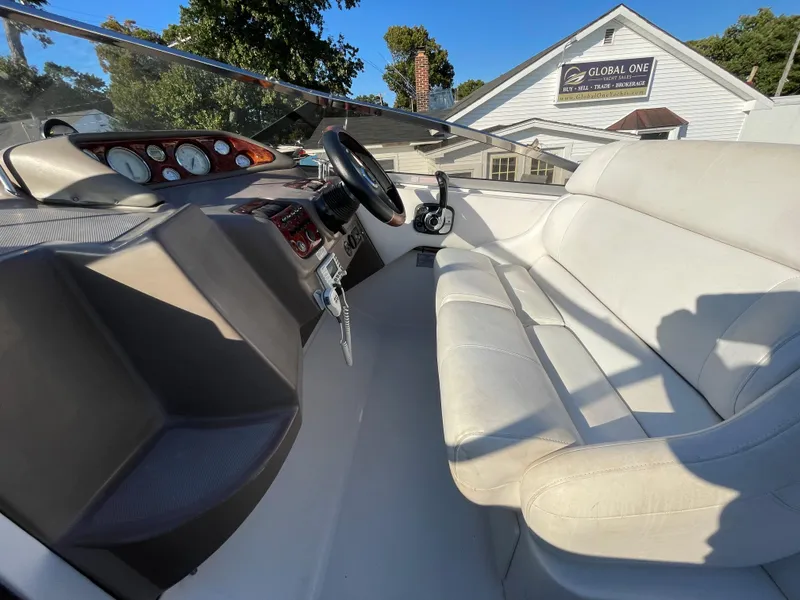 Slide: The Image of Interior of a 2006 Regal 2665 Commodore boat with steering wheel and seating. - 14