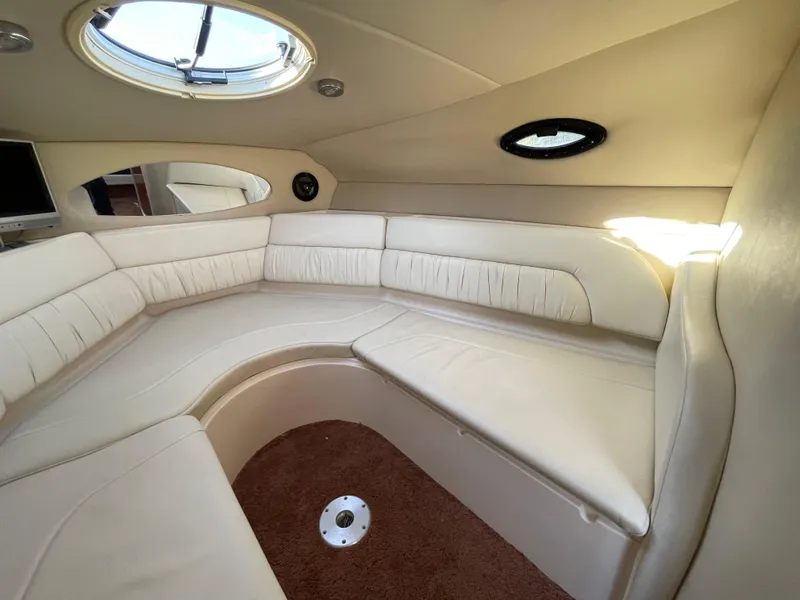 Slide: The Image of 2006 Regal 2665 Commodore cabin interior with beige seating and porthole windows. - 17