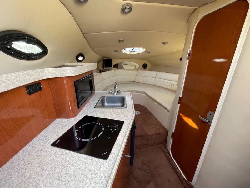 Slide: The Image of Interior of 2006 Regal 2665 Commodore boat with kitchenette and seating area. - 2