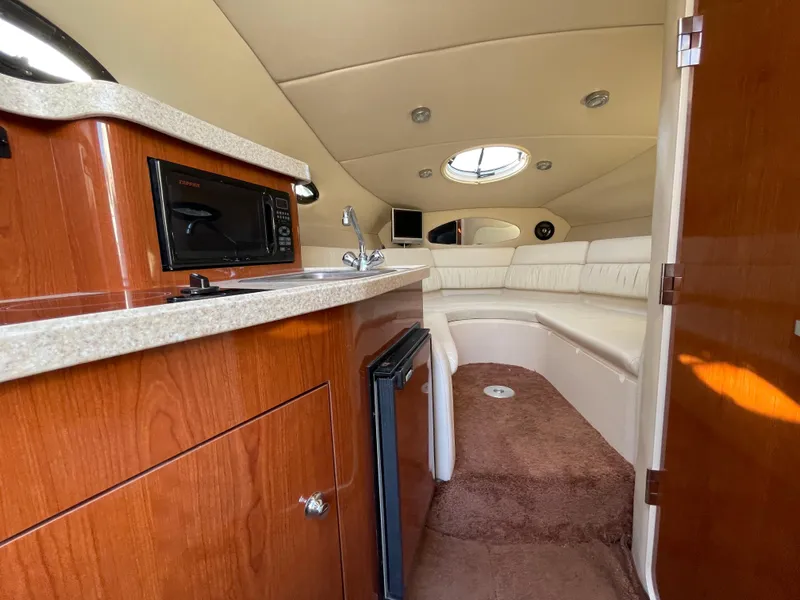 Slide: The Image of Interior of 2006 Regal 2665 Commodore boat with kitchenette and seating area. - 20
