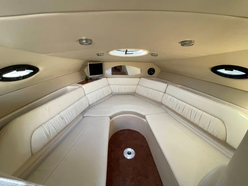 Slide: The Image of Interior cabin of 2006 Regal 2665 Commodore boat with white seating and porthole windows. - 3