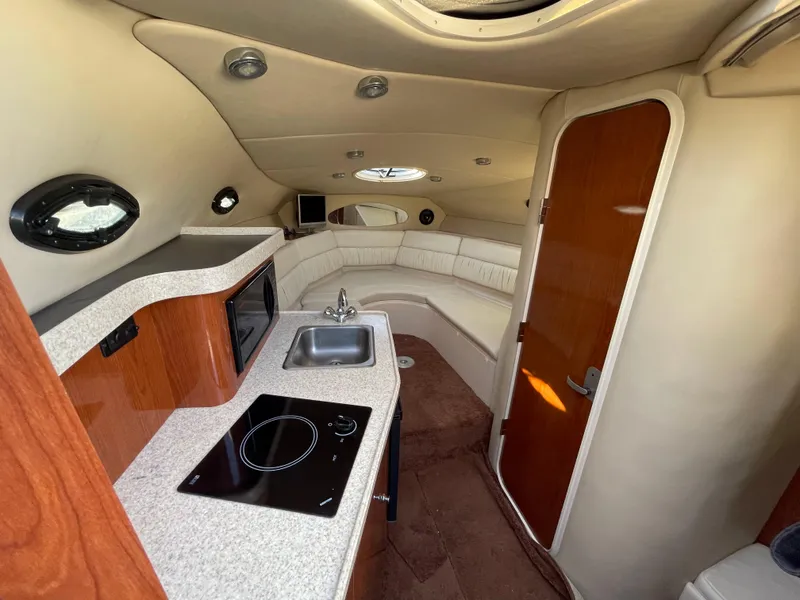 Slide: The Image of 2006 Regal 2665 Commodore cabin interior with kitchenette and seating area. - 4