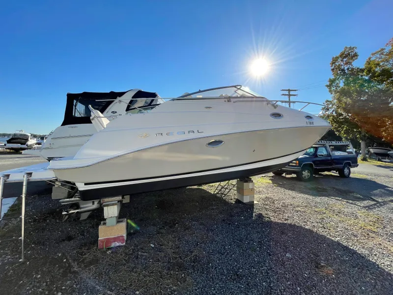 Slide: The Image of 2006 Regal 2665 Commodore boat on dry dock under clear blue sky. - 5