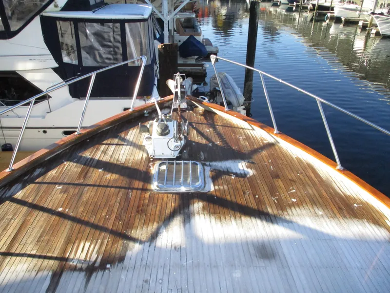 Slide: The Image of 1984 McQueen Flush Deck Motoryacht bow with wooden deck at marina. - 11
