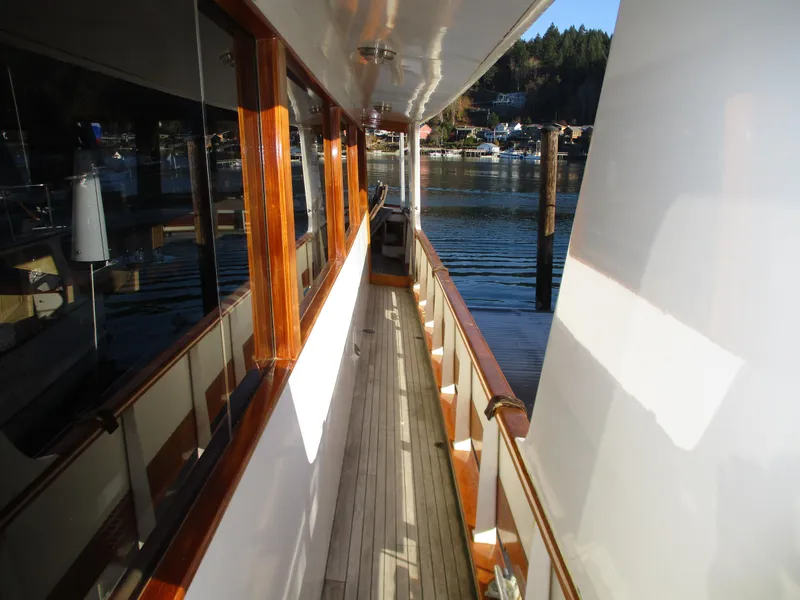 Slide: The Image of 1984 McQueen Flush Deck Motoryacht with wooden deck and waterfront view. - 14