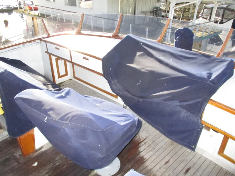 Slide: The Image of 1984 McQueen Flush Deck Motoryacht cockpit with covered seating and wooden accents. - 18