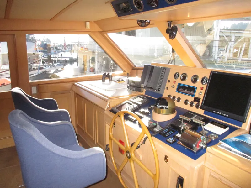 Slide: The Image of 1984 McQueen Flush Deck Motoryacht helm with navigation instruments and blue captain chairs. - 31