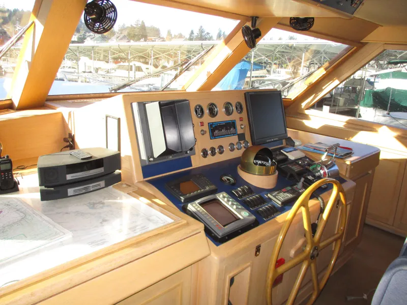 Slide: The Image of 1984 McQueen Flush Deck Motoryacht helm with navigation instruments and wooden steering wheel. - 34
