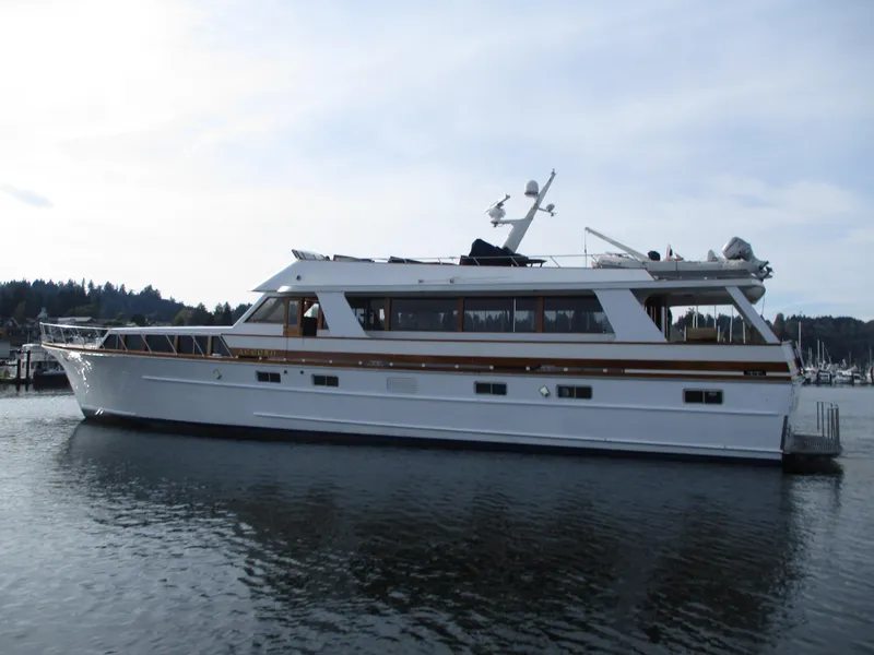 Slide: The Image of 1984 McQueen Flush Deck Motoryacht on calm water, showcasing elegant design and spacious deck. - 4