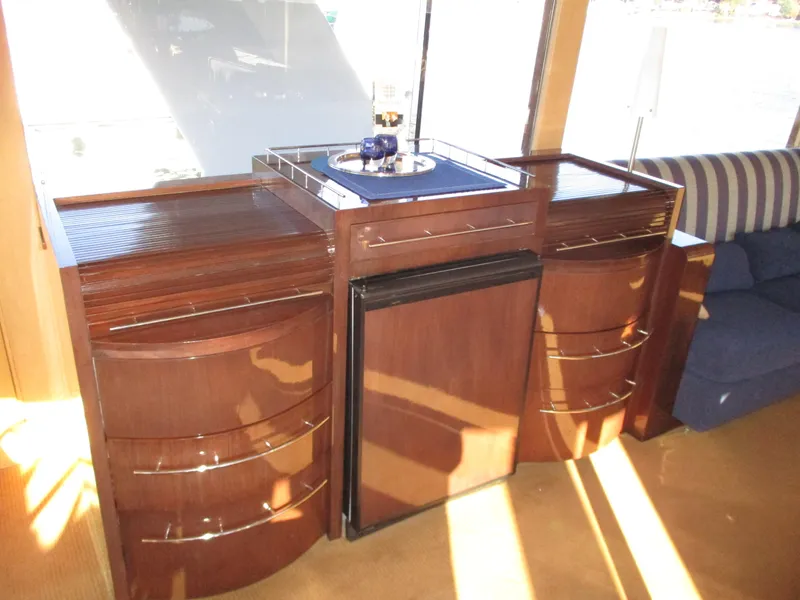Slide: The Image of 1984 McQueen Flush Deck Motoryacht interior with wooden cabinetry and mini fridge. - 41