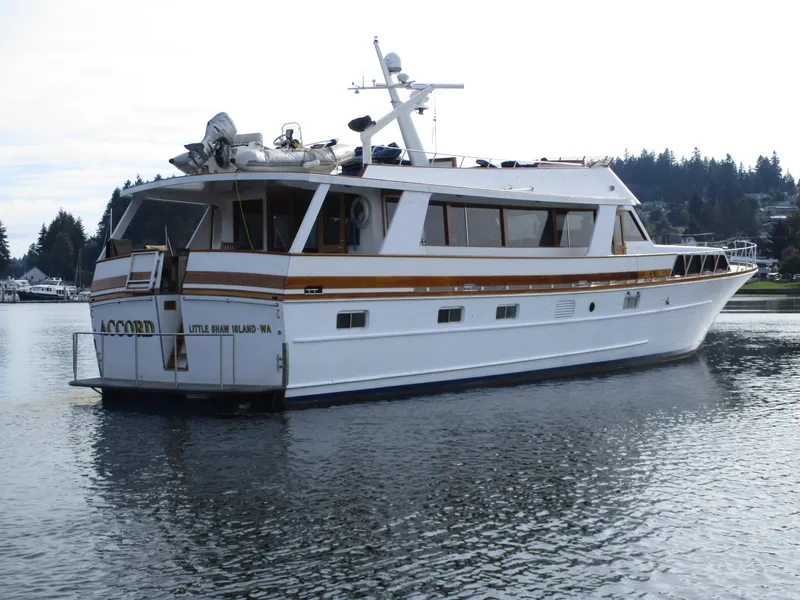 Slide: The Image of 1984 McQueen Flush Deck Motoryacht on calm water, featuring a sleek design and spacious deck. - 6